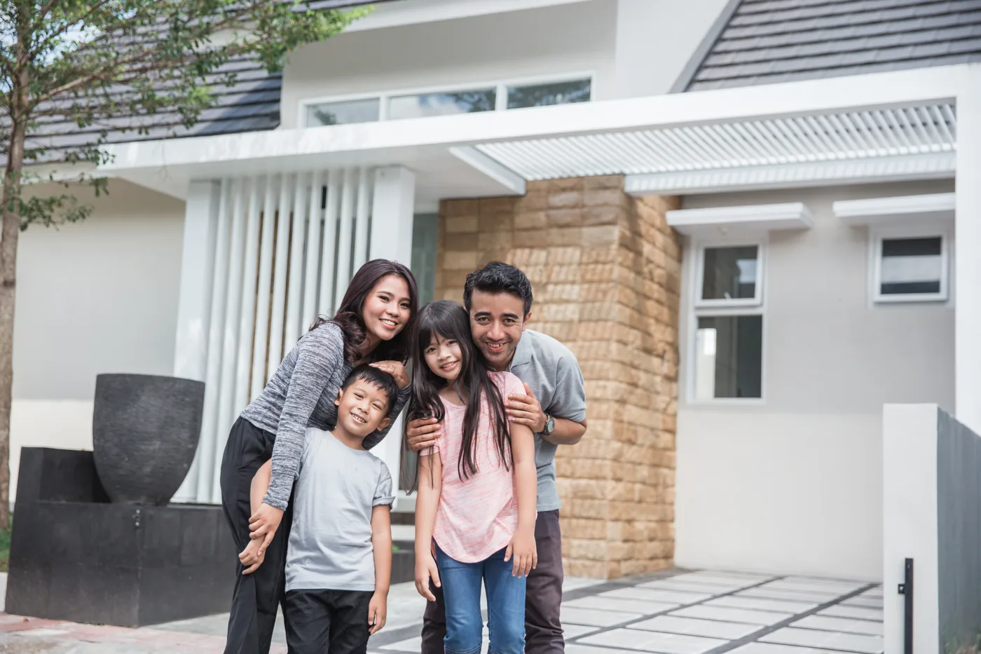 Smiling family standing in front of their Florida home