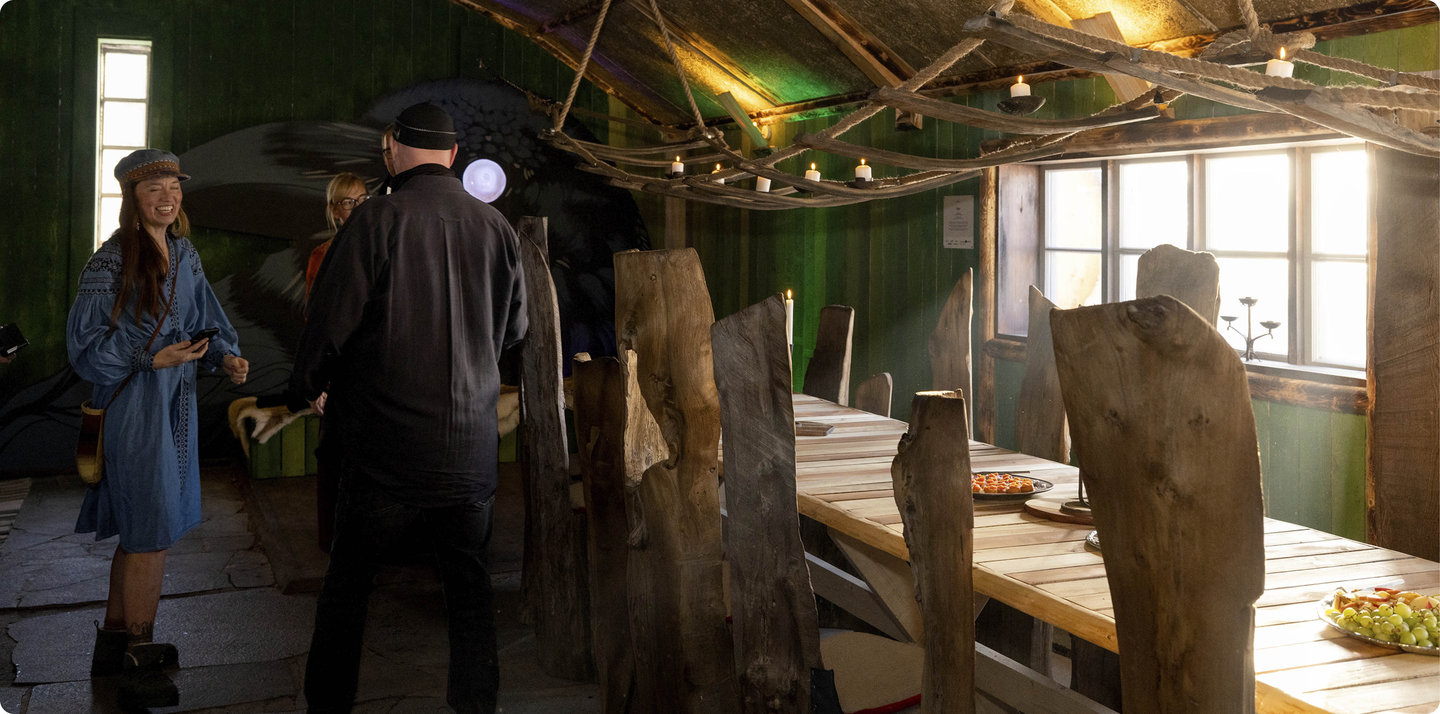 Linda Kalkan tillsammans med gäster, stående inne i Ögat, med specialgjord inredning och fat med tilltugg uppdukat på borden. 