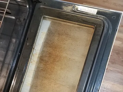 Before a deep cleaning in Miami: baked on grease on the oven door glass