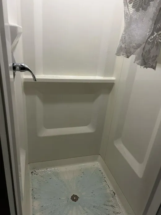 Before a deep cleaning in Miami: soap scum and grime on the shower floor