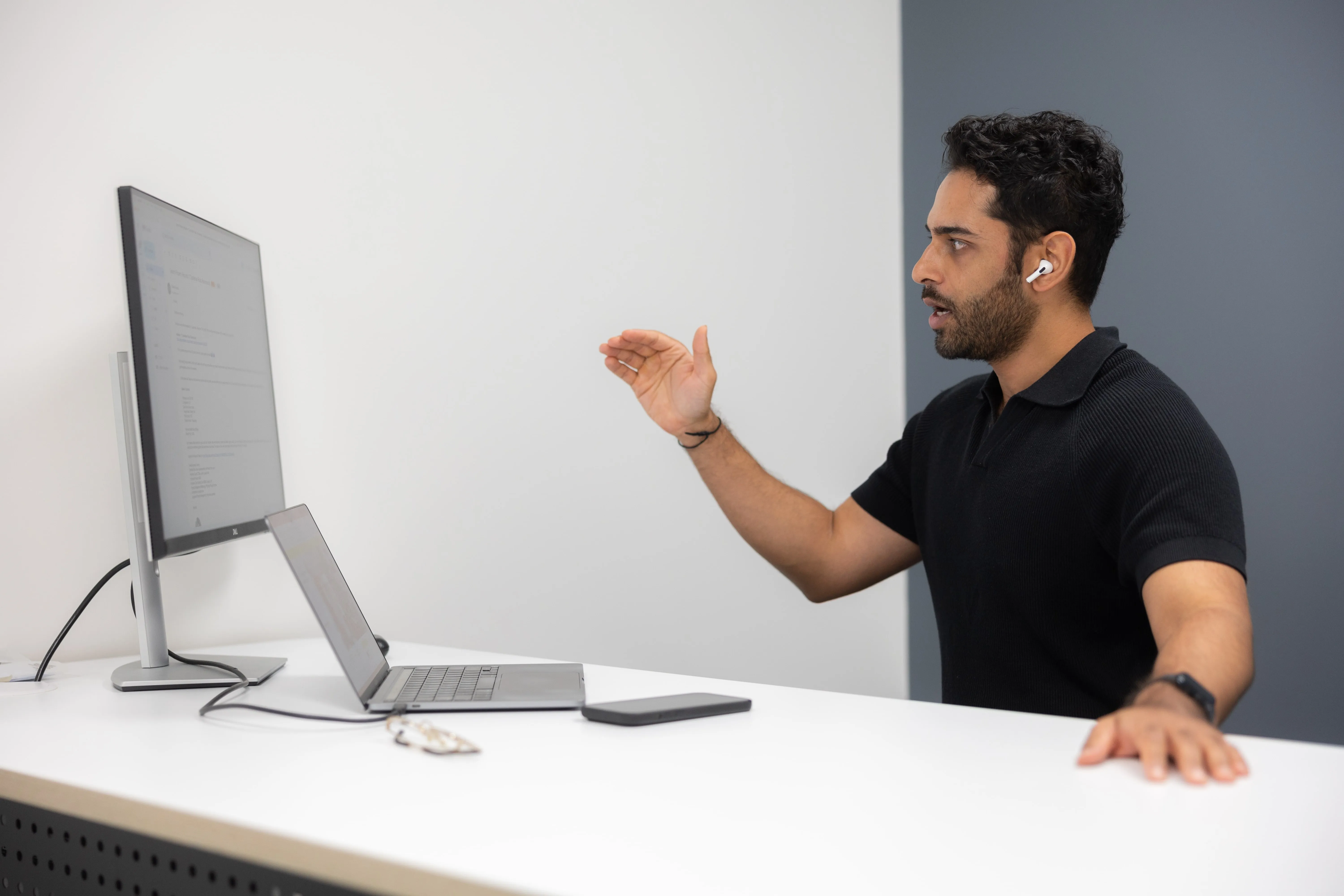 A man standing in front of a computer screen.