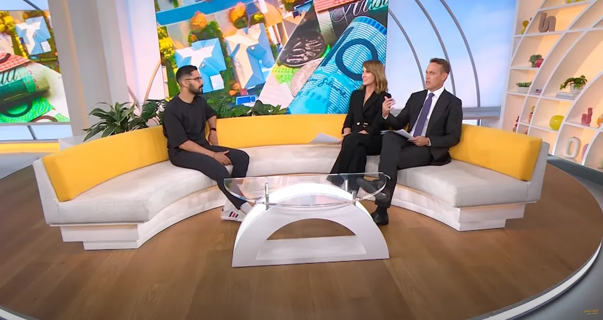 Ravi during TV show sitting on top of a couch.