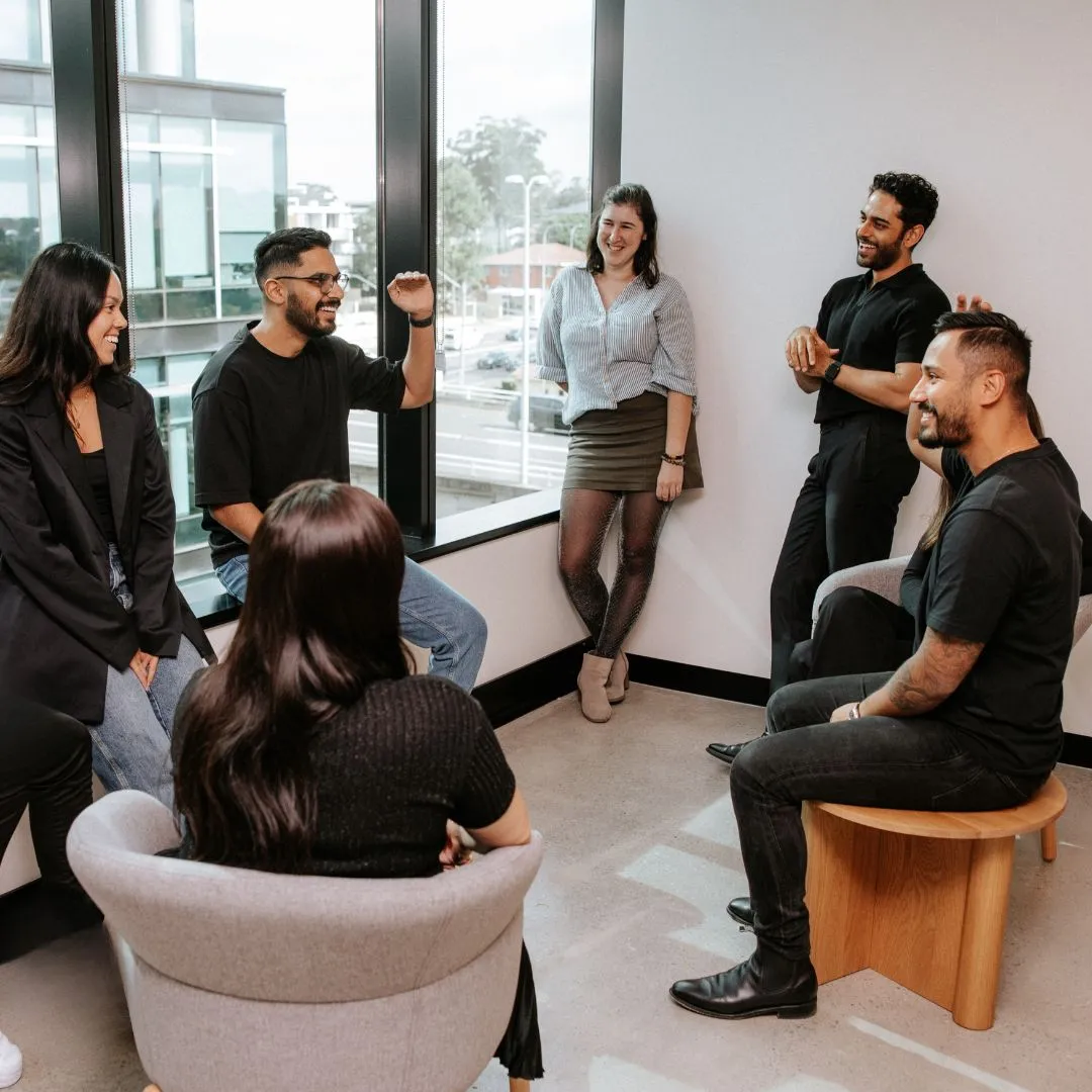 A group of people sitting around a room.
