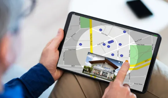 Person using tablet with interactive real estate map and property listings during home search
