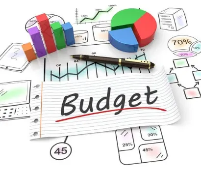 A budget planning concept featuring colourful charts, graphs, a pen, and a notepad with the word 'Budget' written on it.