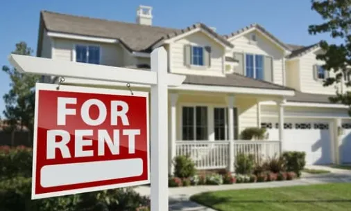 A house with a 'For Rent' sign in front, indicating the property is available for leasing.