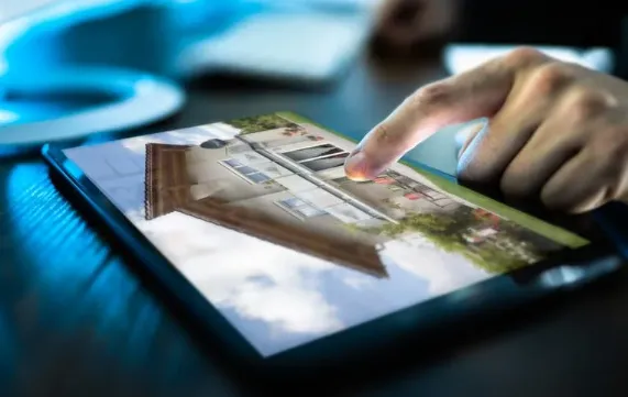 Hand browsing property listings on a digital tablet, showcasing modern online real estate search experience.