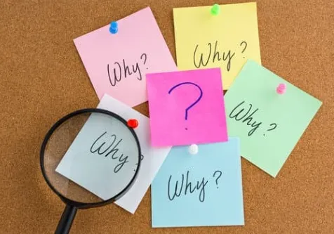 Sticky notes with words “Why” written on them, along with a red pin and magnifying glass