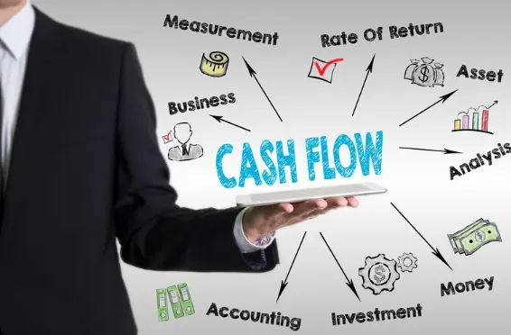 Businessman in suit presenting a tablet with "Cash Flow" surrounded by financial terms like investment, accounting, and rate of return.