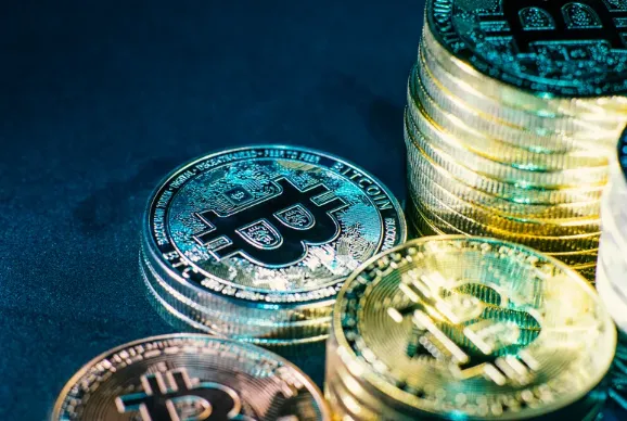 Close-up view of shiny physical Bitcoin coins stacked together, representing digital asset investments and alternative financing for real estate.