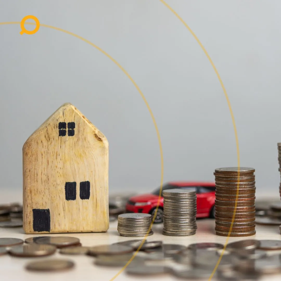 Wooden house model with stacked coins and a red toy car symbolizing property investment, savings, and financial growth.
