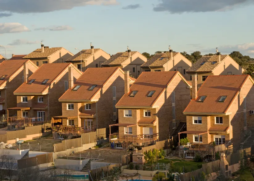  Row of modern suburban houses with red-tiled roofs, representing residential property investments in Australia.