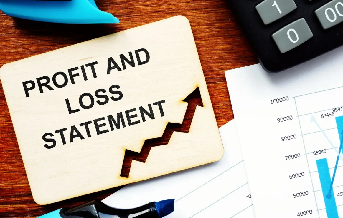 Profit and loss report with calculator and financial graphs showing business figures