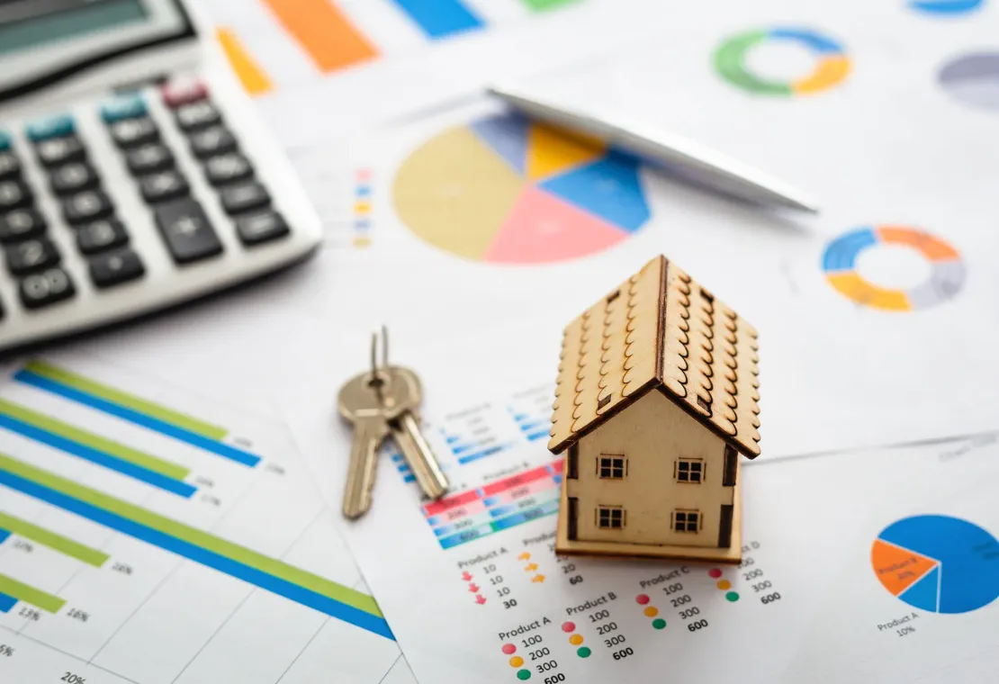 Miniature house and keys, with business data and calculator.