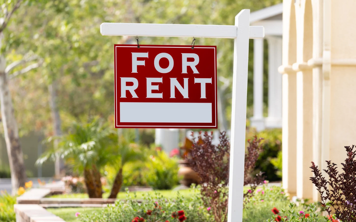 Alt text: Red sign that says “For Rent”