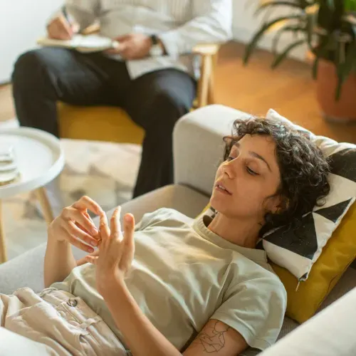 a woman laying on top of a couch next to a man