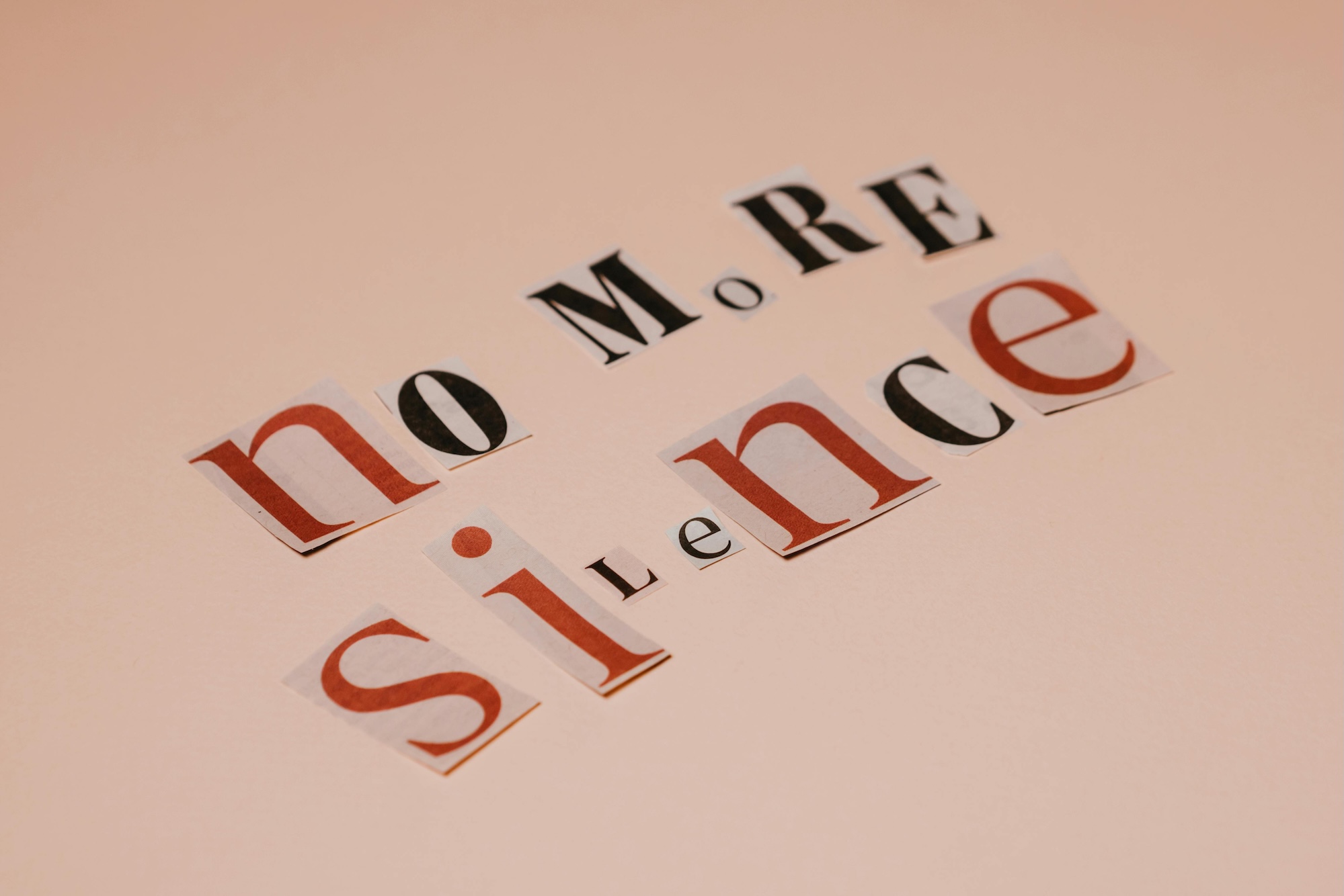 The image shows cut-out letters from a magazine that say "no more silence"