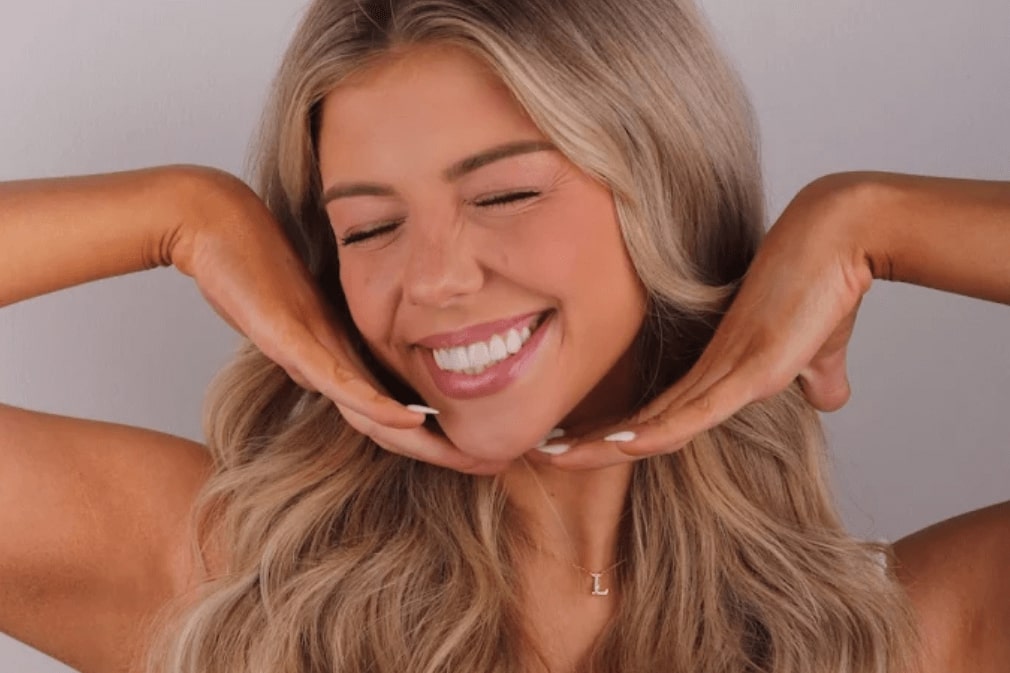 Woman smiles, showing off her beautiful, healthy smile after the best smile makeover in Houston, TX.