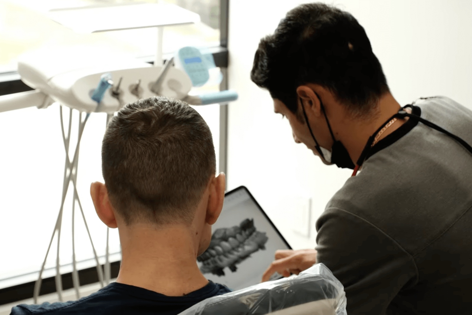 The best cosmetic dentist in Houston studies dental X-rays with an assistant to plan the ideal smile makeover for a patient