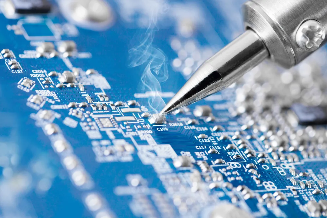Soldering iron on a circuit board during micro soldering repair