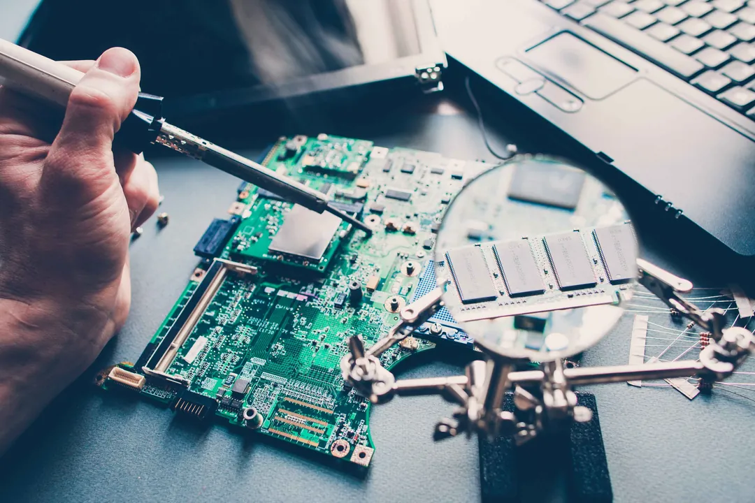 Close-up repair work on a laptop motherboard