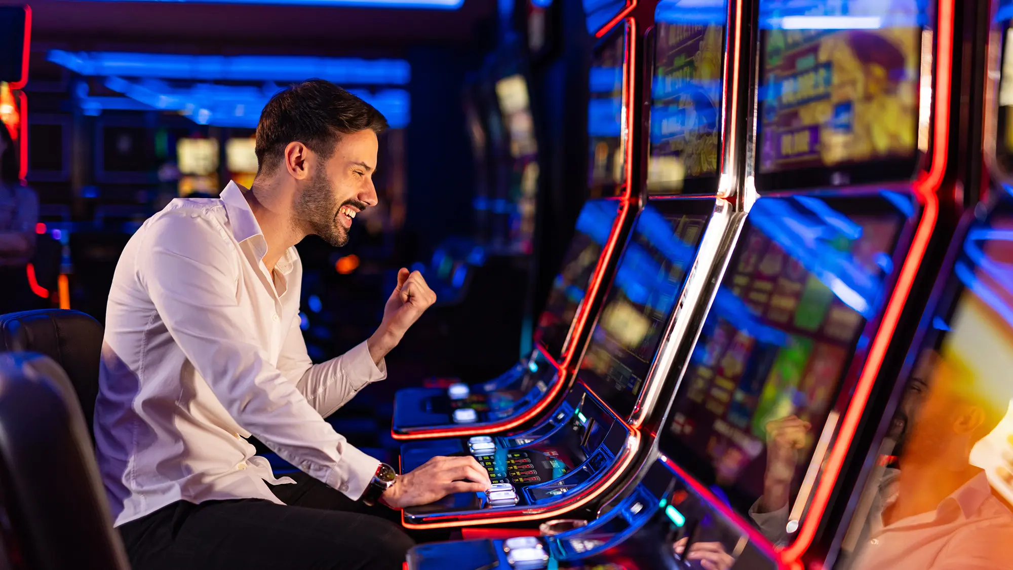 Man using a gaming machine, representing member onboarding, ongoing compliance checks and real-time risk management.