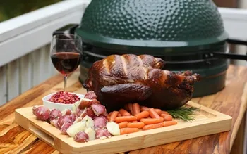 a large turkey sitting on top of a cutting board next to a glass of wine