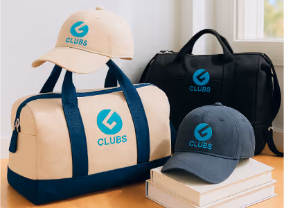 Beige and black duffel bags, beige and gray caps with blue G Clubs logo, two caps rest on duffel bags and two books.