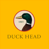 Logo of a duck head illustration inside a circle with the year 1865 and the text 'DUCK HEAD' below on a yellow background.
