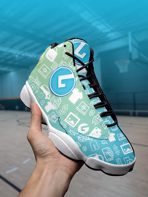 Hand holding a custom basketball shoe with a turquoise and green pattern featuring icons like shopping bags, dollar signs, and clothing in a basketball court background.