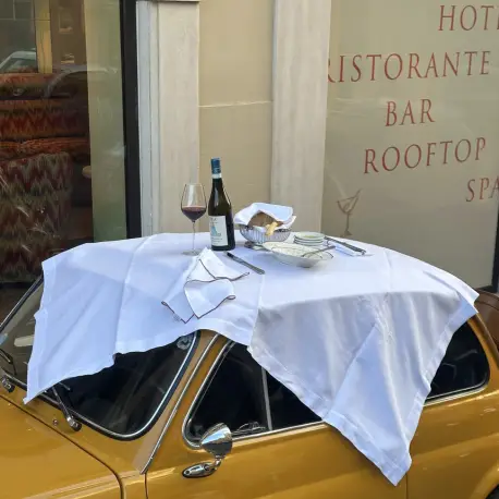 Italian restaurant table set on the Casa Monti vintage yellow Fiat car