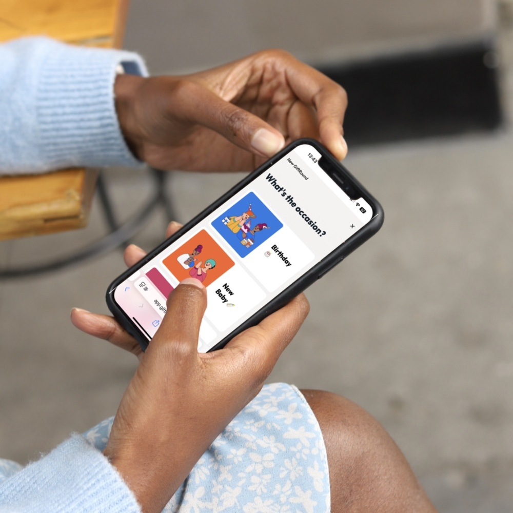 Person holding a phone and creating a free GiftRound group collection.