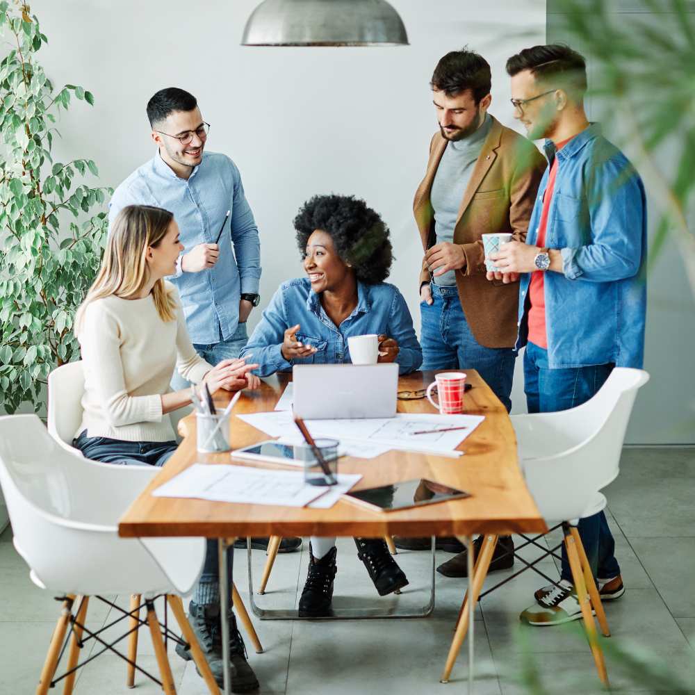 Group of colleagues with one a the centre smiling in an office 