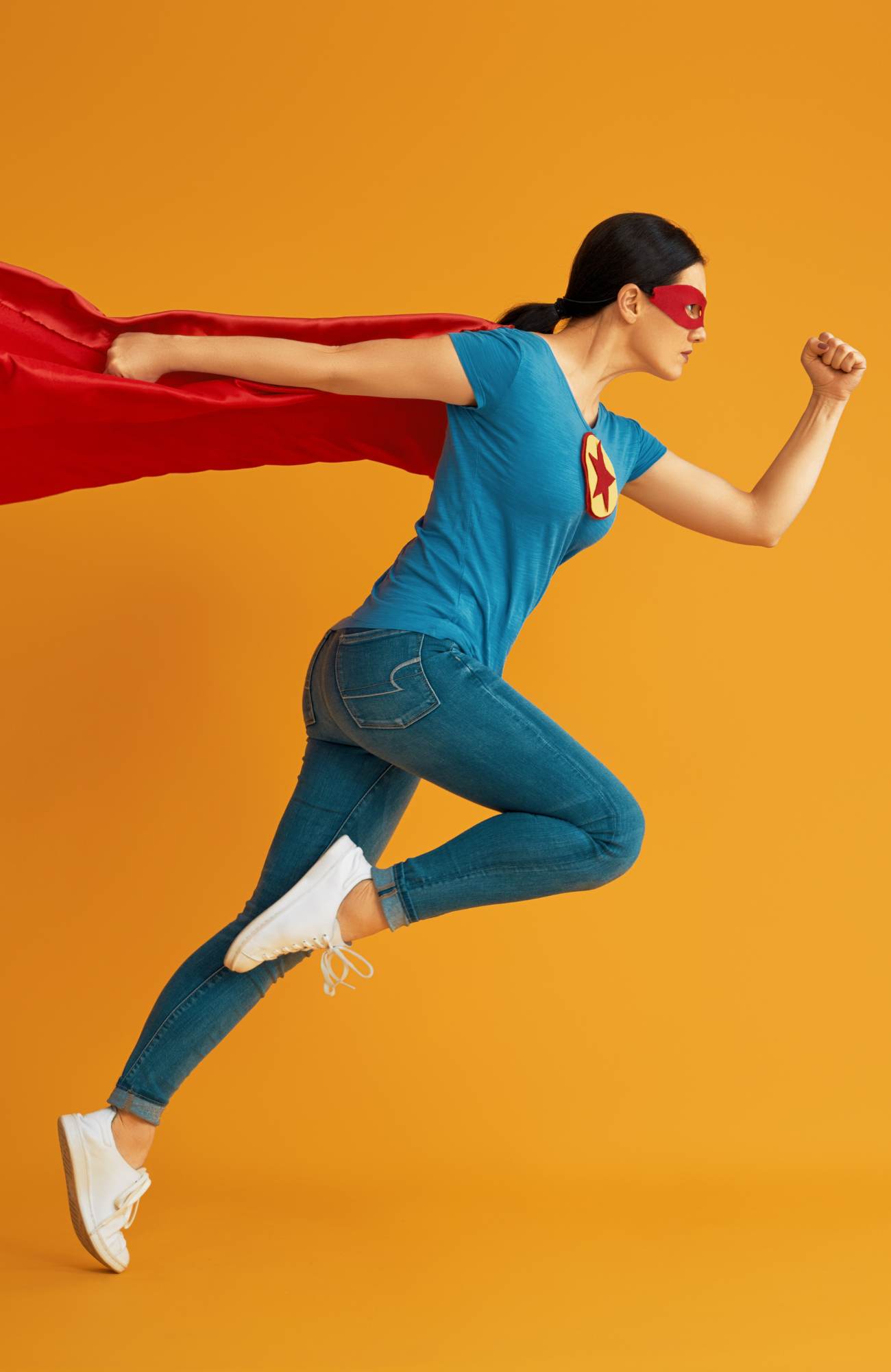 Person dressed as a superhero in a flying position