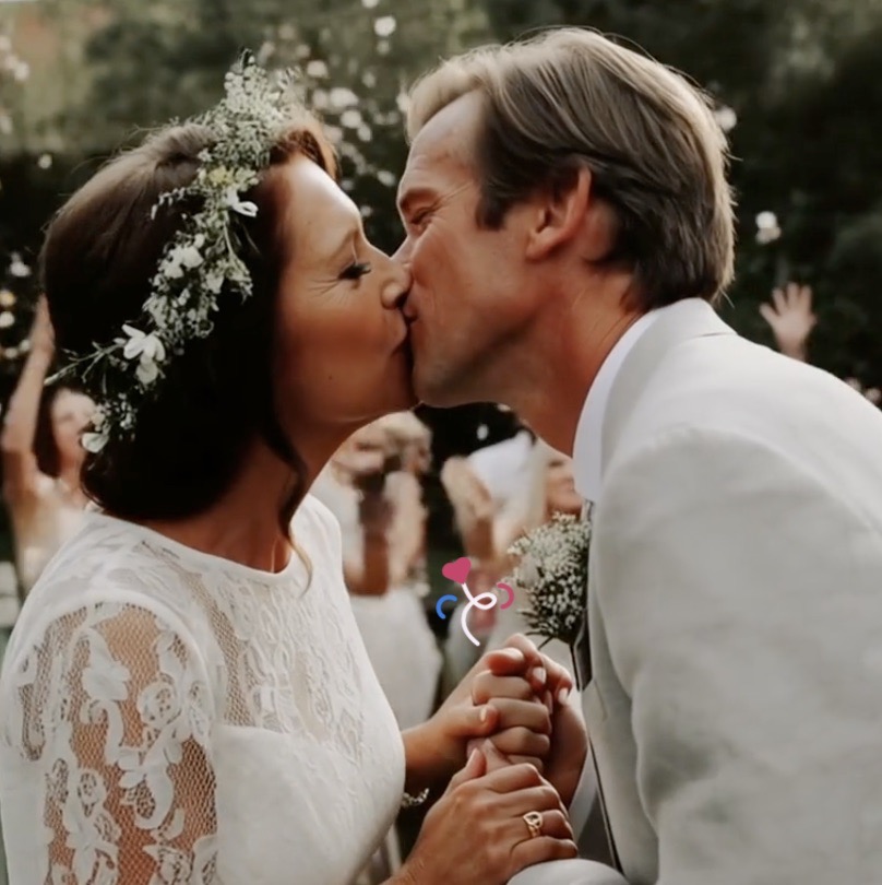 Couple kissing under falling confetti.