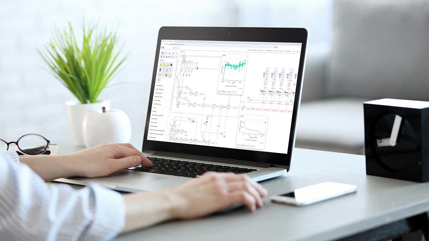 Engineer using Hysopt Simulator to analyse and validate complex hydronic HVAC system performance on a laptop.