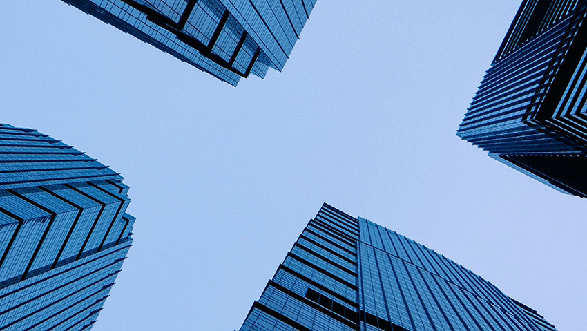 Modern high-rise buildings viewed from below, representing complex commercial buildings where reliable hydronic HVAC commissioning supports long-term system performance.