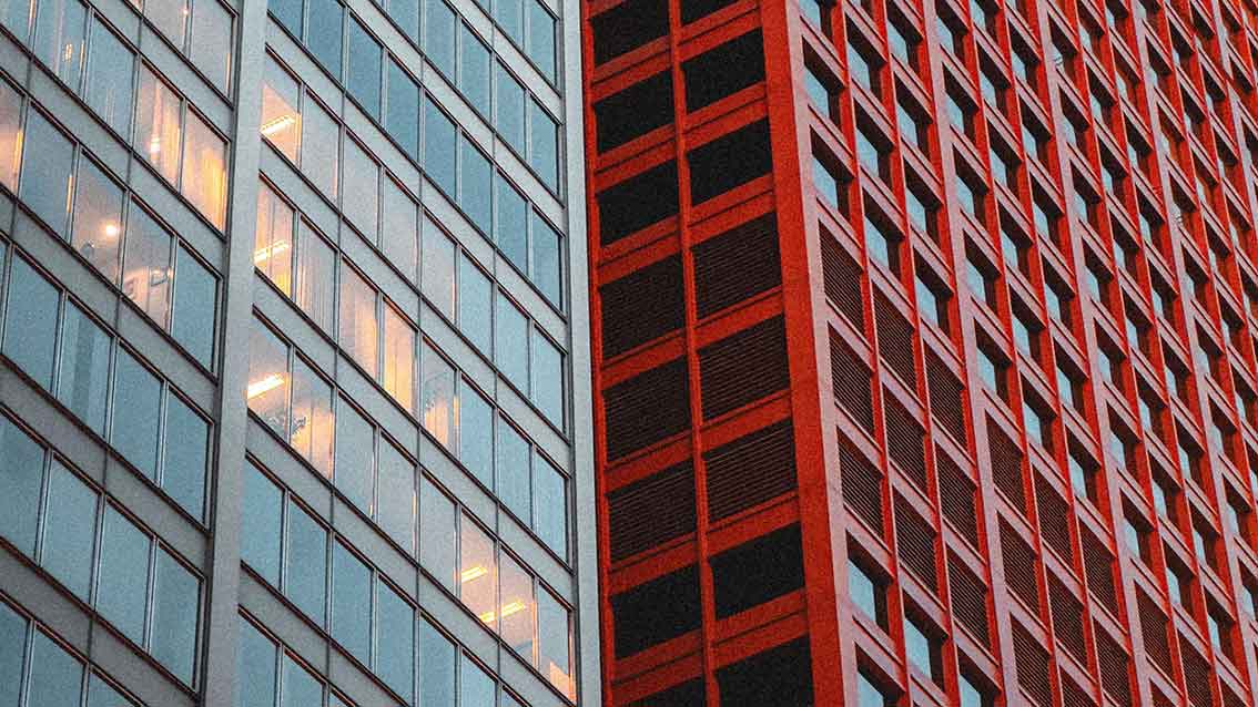 Modern commercial building façades, representing HVAC projects where system performance can differ from design intent after handover.