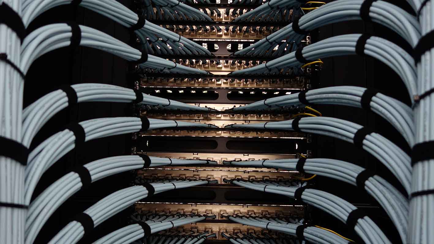 Netwerkbekabeling in een serverrack van een datacenter, als symbool voor bedrijfszekere infrastructuur en koelredundantie voor kritieke IT-systemen.