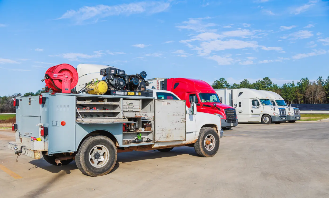 Mobile diesel mechanic performing air compressor repair onsite.
