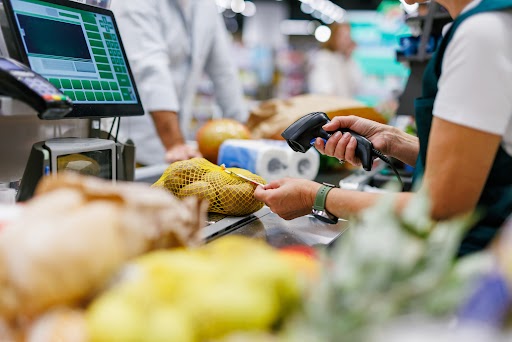 Shopper scanning a pack at a supermarket checkout