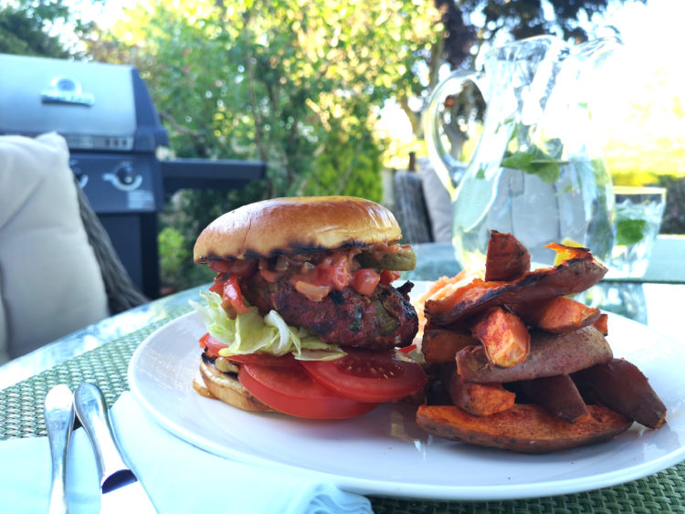Homemade burgers with relish and sweet potato wedges