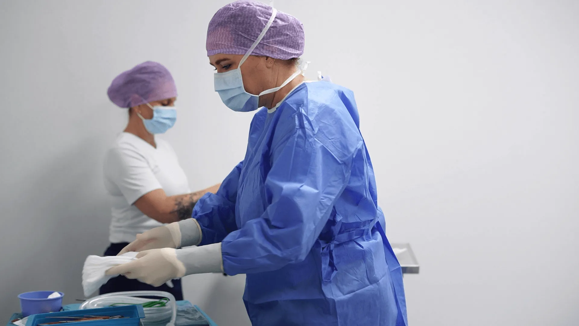 A couple of people in scrubs and masks.