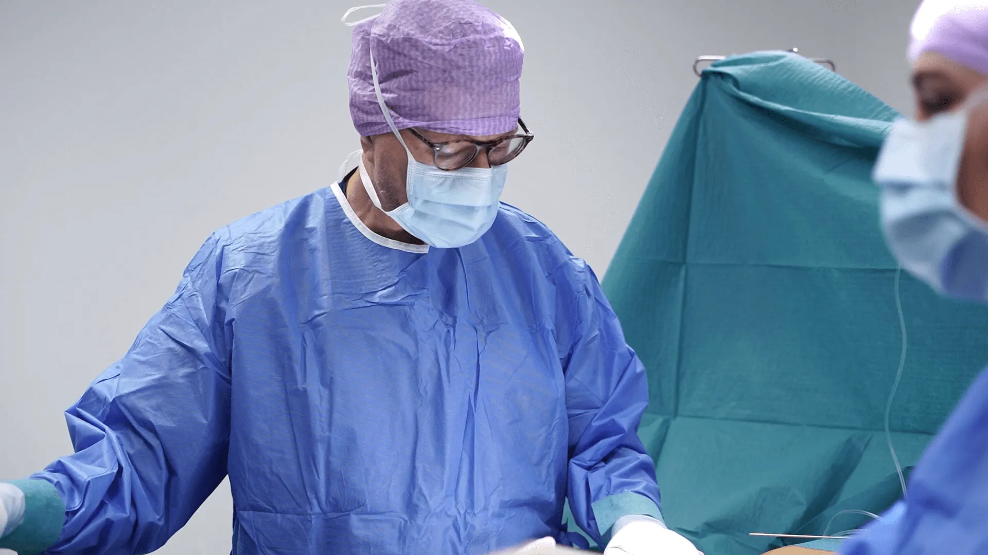 Two surgeons are performing surgery on a patient.