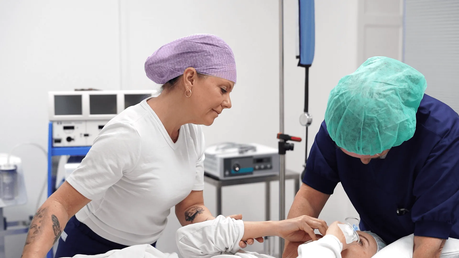 A woman in a white shirt and a man in a blue scrub.