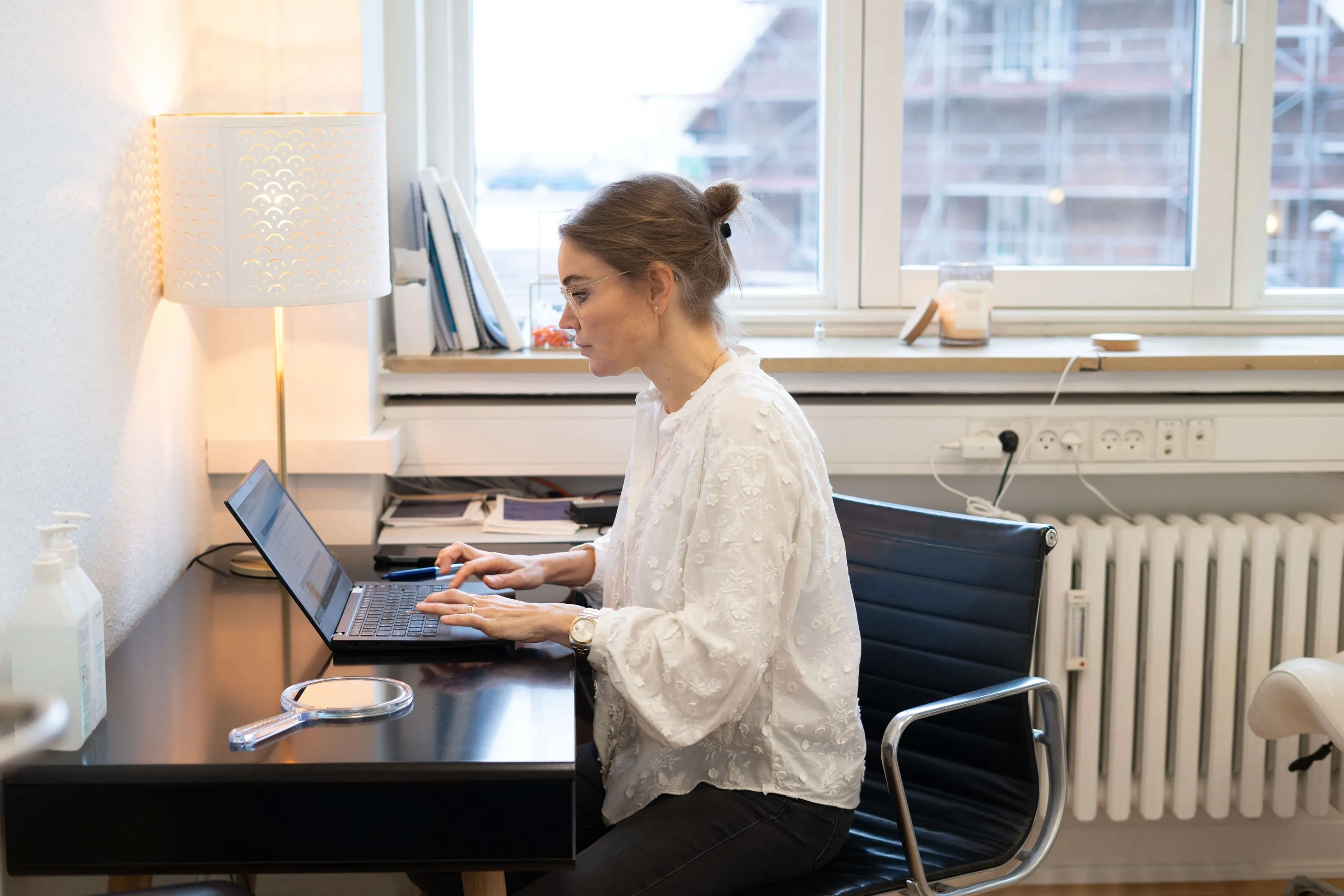 A woman sitting at a desk using a laptop computer.