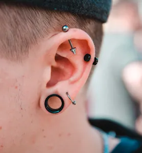 A pierced ear with pins and stretches