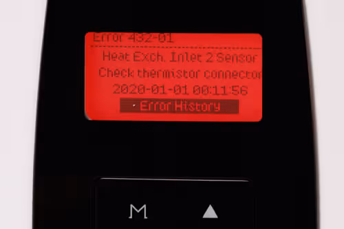 Person using a wrench to fix a leaking white kitchen pipe under a sink with water flowing out.