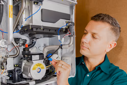 Ceiling light fixture surrounded by a large water stain indicating a ceiling leak.
