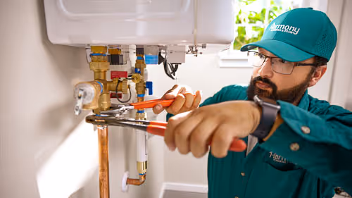 Wall-mounted light fixture above a water stain on the wall indicating a leak.